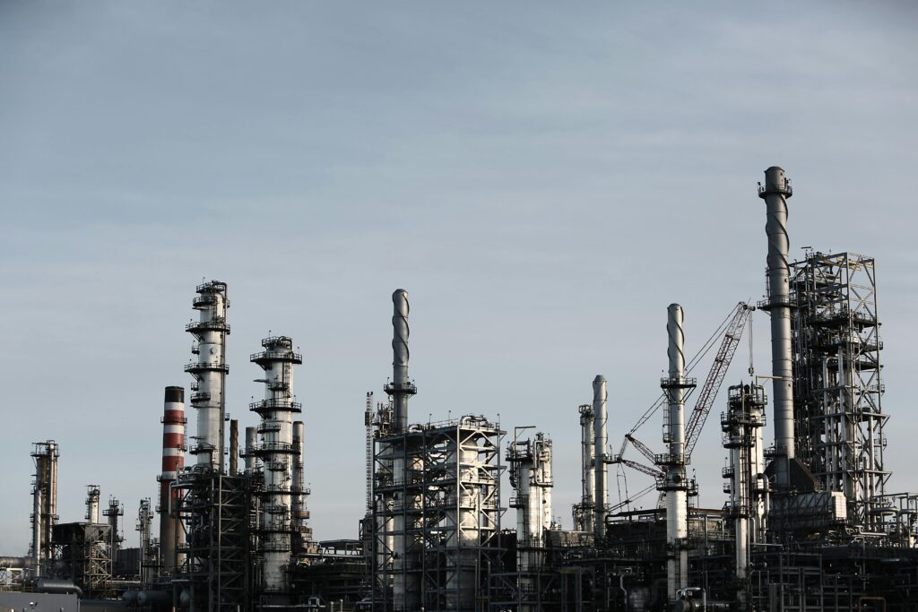 Skyline view of an industrial factory with tall chimneys against a clear sky.