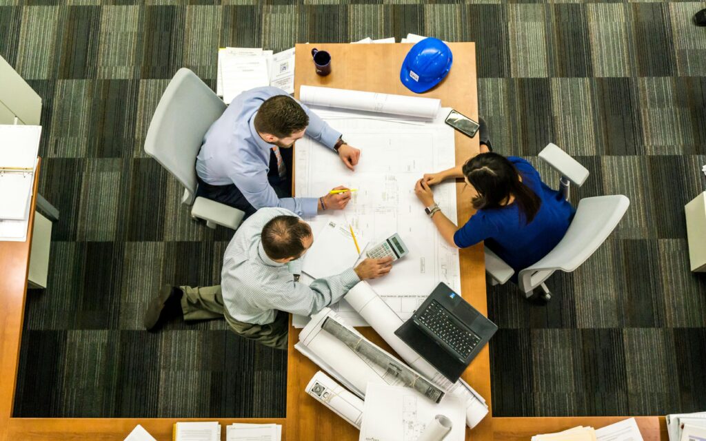 Top view of a team working on construction plans in an office setting.