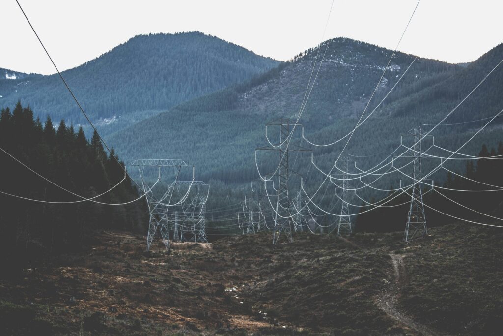 Power lines stretch across a rugged mountain landscape, showcasing infrastructure in nature.