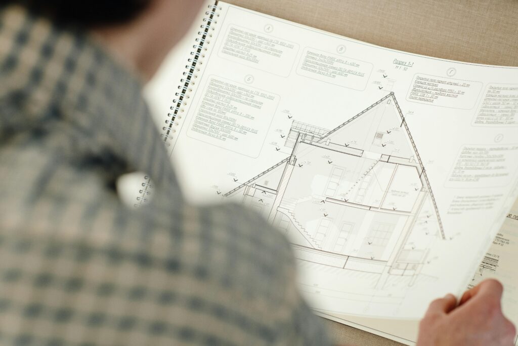 Close-up of person examining an architectural floor plan with intricate design details.