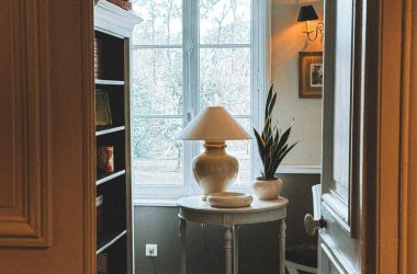 Cozy interior featuring a chandelier, large window, and decorative carpet.